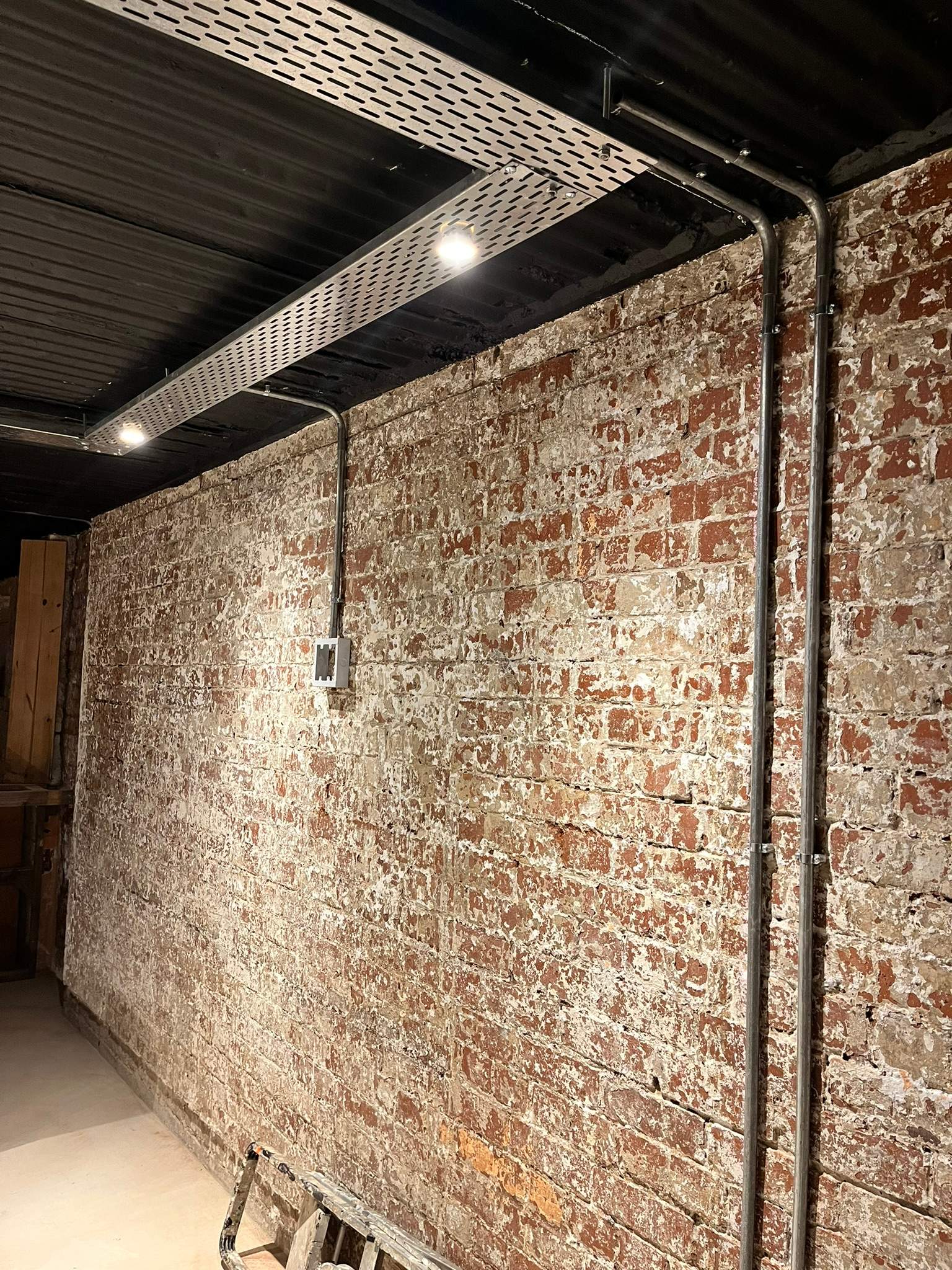 Exposed metal conduit used as part of a DG Technologies entertainment room installation