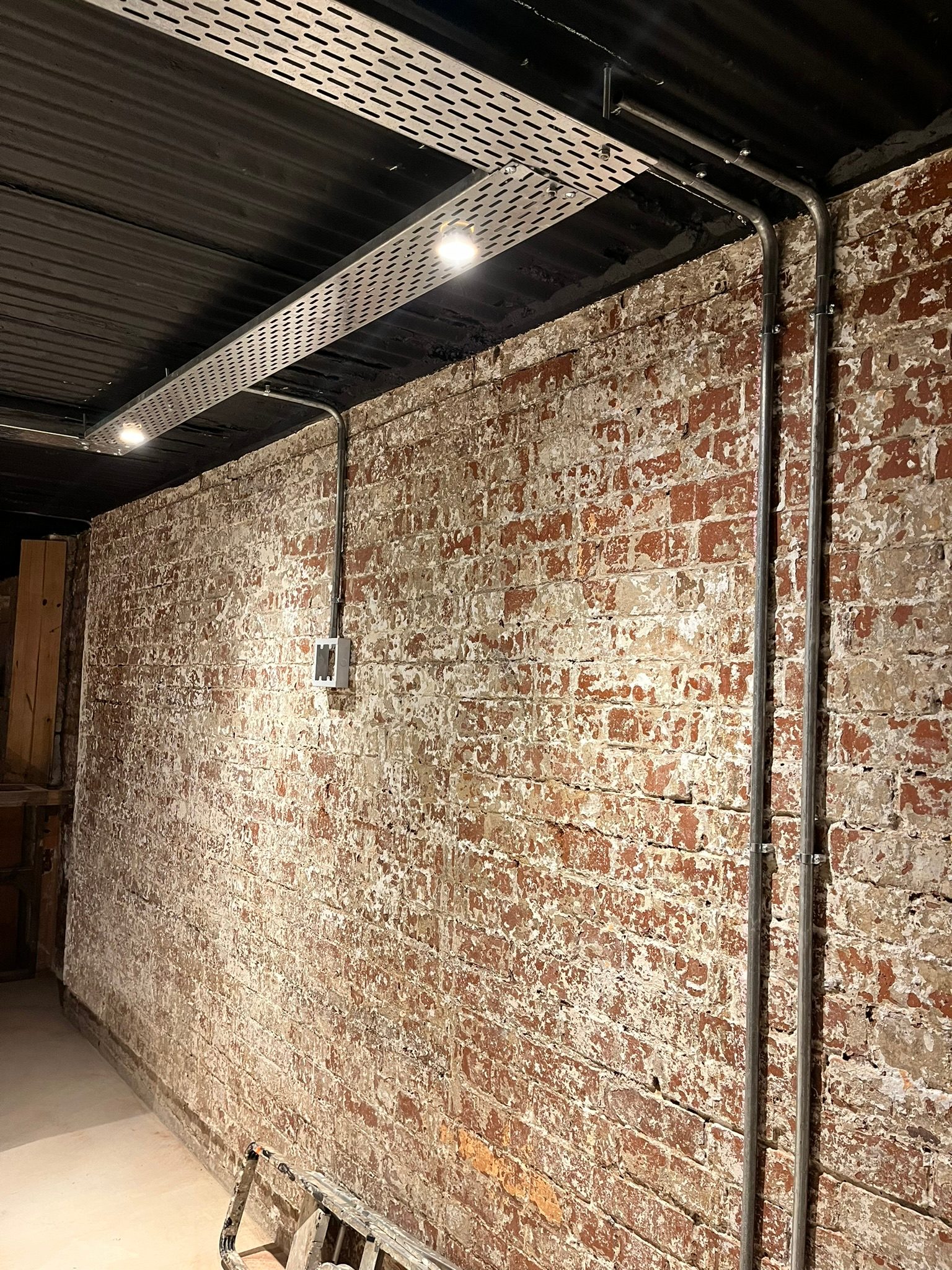 Exposed metal conduit used as part of a DG Technologies entertainment room installation